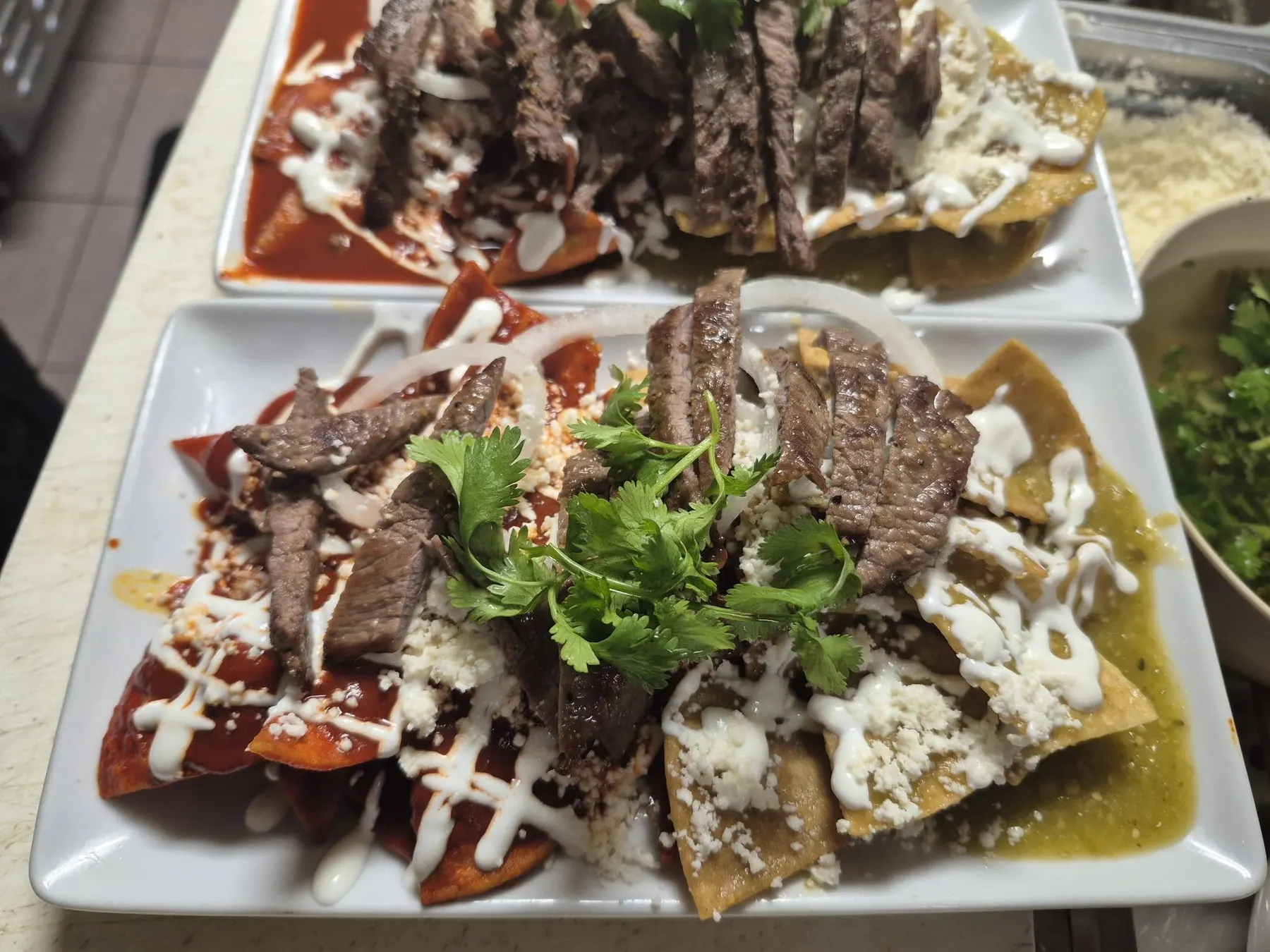 Mia's chilaquiles with steak, red and green salsa, queso fresco and cilantro